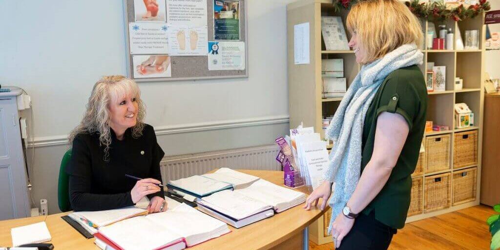 A woman arriving at reception at Footprints Podiatry Clinic, Hull